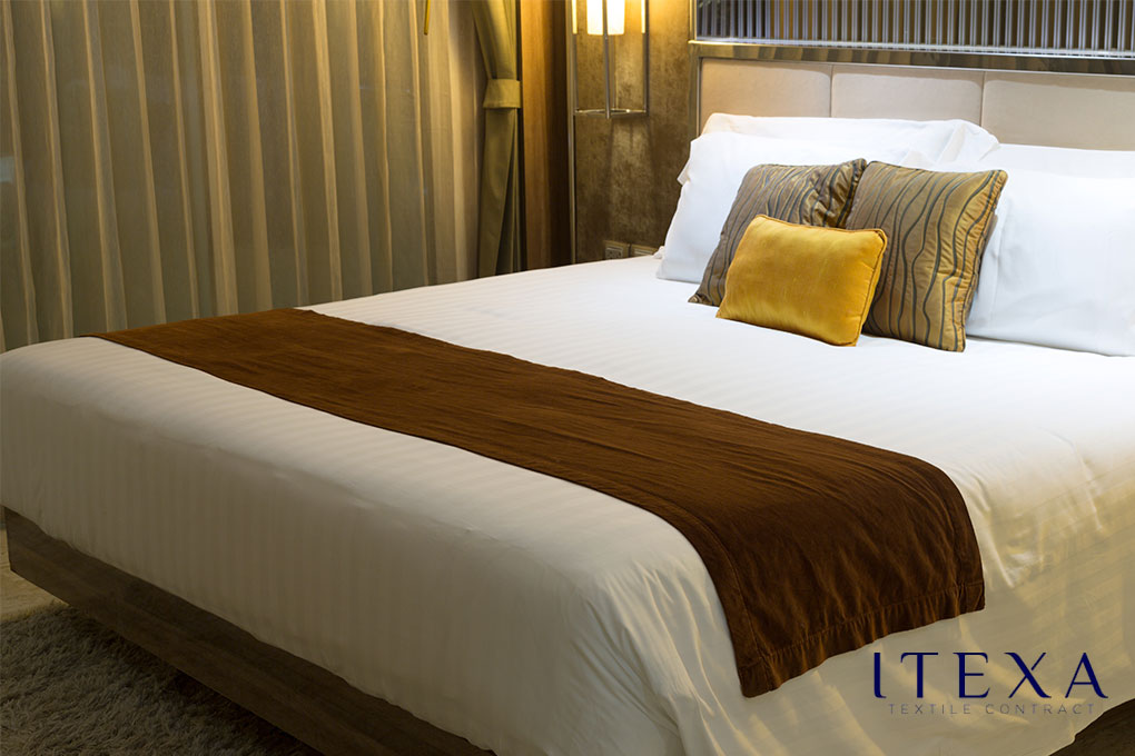 Elegante plaid marrón sobre una cama de hotel