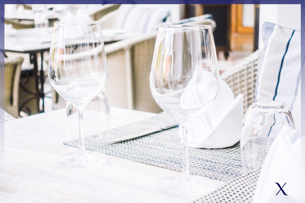 mesa de restaurante con dos copas vacías y servilleta blanca con forma