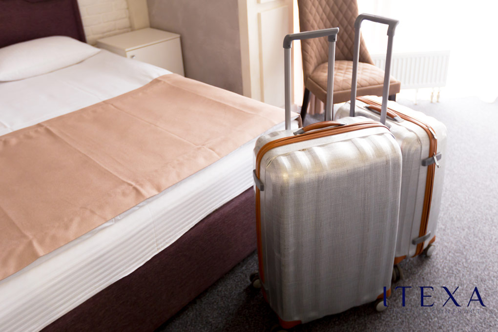 dos maletas junto a una cama de hotel